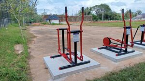 เครื่องออกกำลังกายกลางแจ้งโครงเหล็กพ่นสีแดง ติดตั้งบนแท่นฐานคอนกรีต
